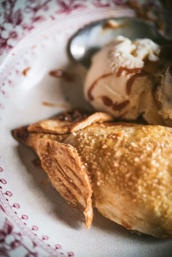 closeup of pastry covered pears in a bowl with ice cream