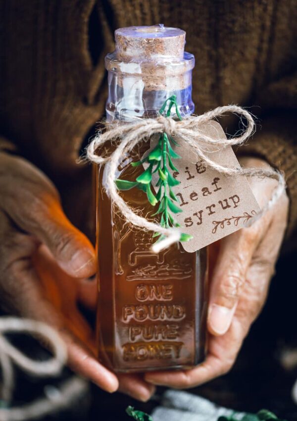 hands holding jar of fig leaf syrup